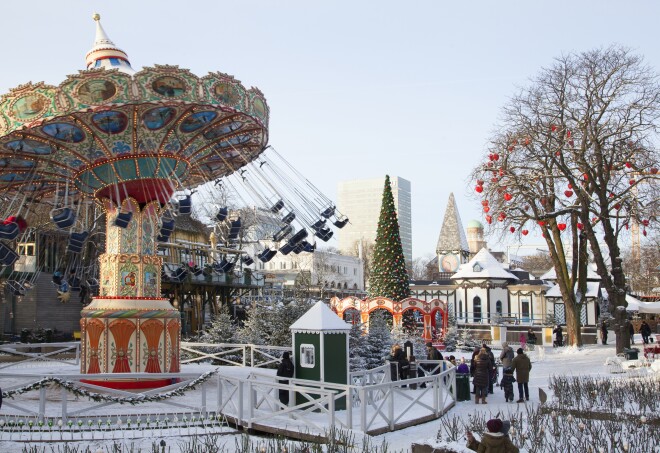 People gathering in an amusement park covered in snow at the Tivoli Gardens in Copenhagen.