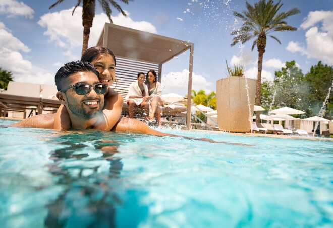 A smiling man and child swimming in a pool together in Orlando, Florida