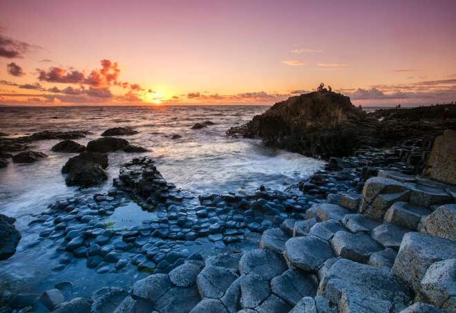 The sun setting over the patterned rock formations of Giant’s Causeway, Ireland