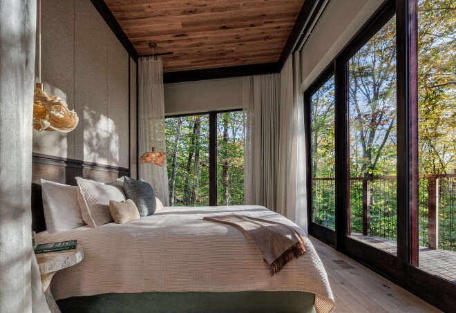 This bedroom of a treehouse accommodation at Twin Farms in Vermont has floor to ceiling windows with views of the area's birch forest.